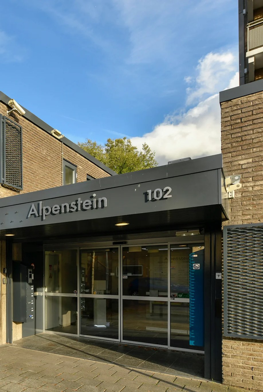 Ingang van het gebouw Alpenstein, nummer 102, aan de Alpen Rondweg