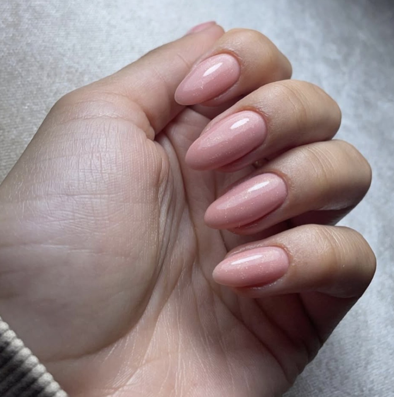 Close-up van amandelvormige BIAB-nagels in zacht roze