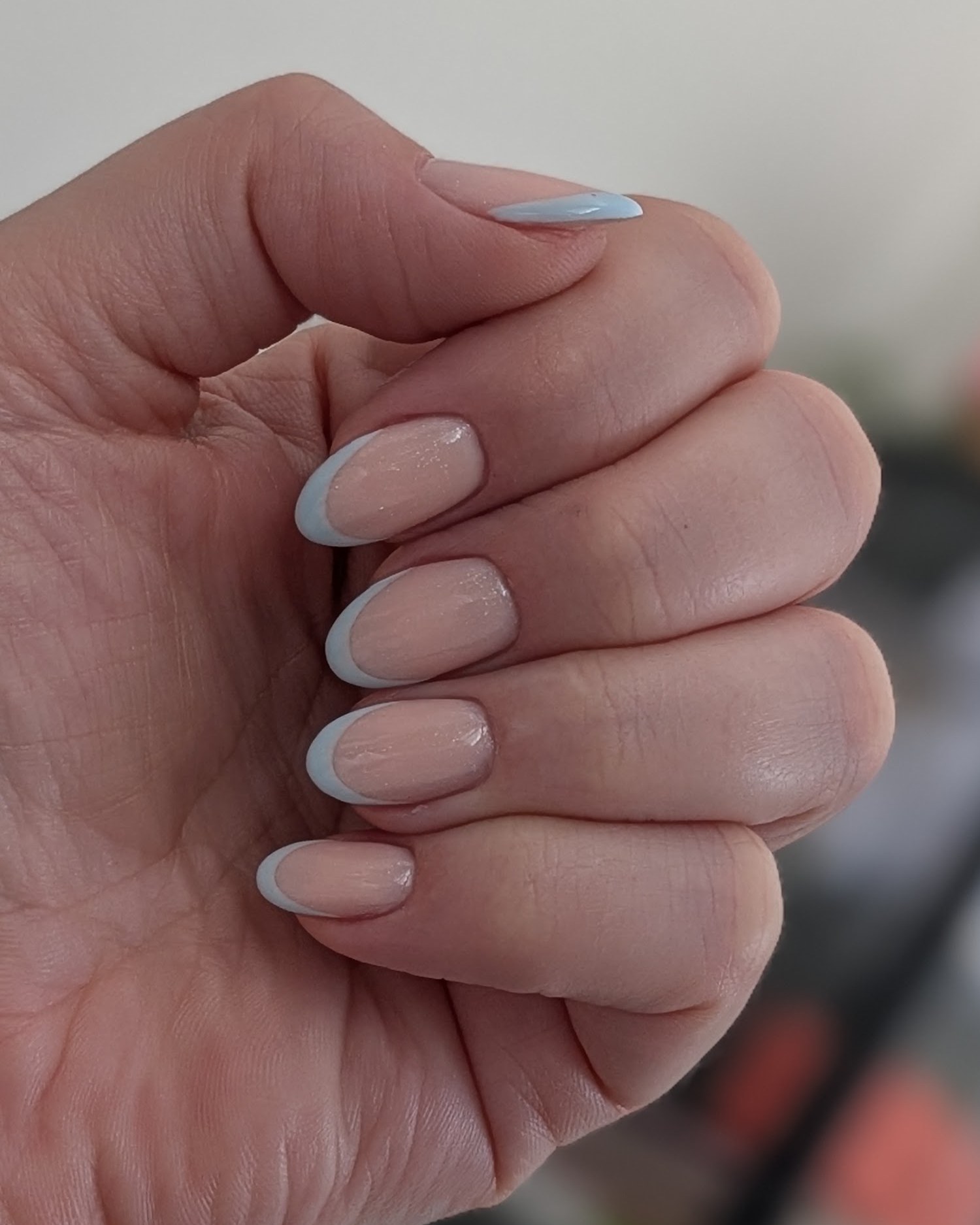 Hand met lichte, nude amandelvormige nagels